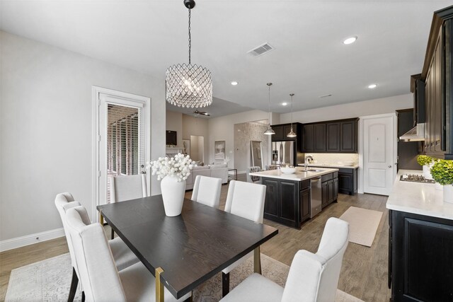 dining room featuring a chandelier, recessed lighting, baseboards, light wood-type flooring, and visible vents