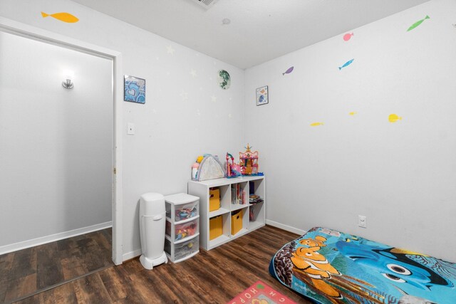 recreation room featuring baseboards and wood finished floors