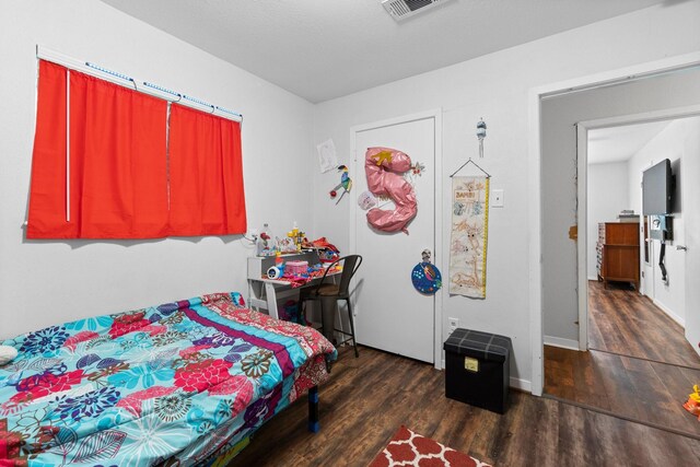 bedroom featuring wood finished floors and visible vents