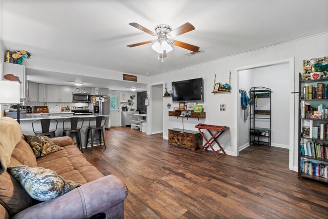 living area featuring ceiling fan, dark wood finished floors, baseboards, and visible vents