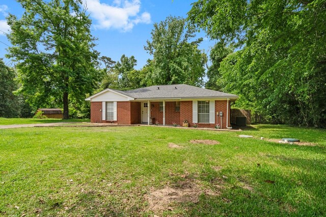 single story home featuring central AC unit, a front yard, and brick siding