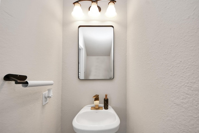 bathroom featuring a sink and a chandelier