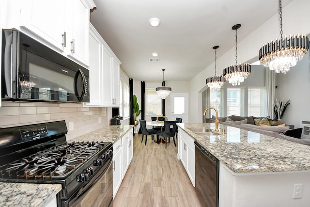 kitchen with white cabinets, a sink, a chandelier, decorative backsplash, and black appliances