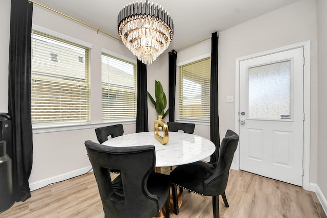 dining area featuring baseboards, a notable chandelier, and light wood-style floors