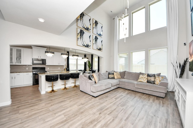living area featuring a high ceiling and light wood-style floors