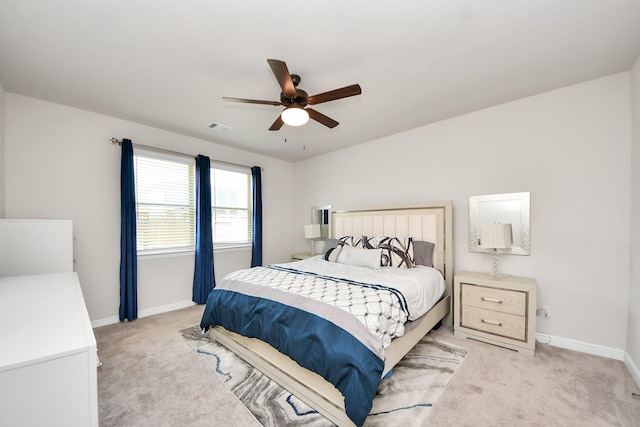 bedroom featuring baseboards, a ceiling fan, visible vents, and light carpet