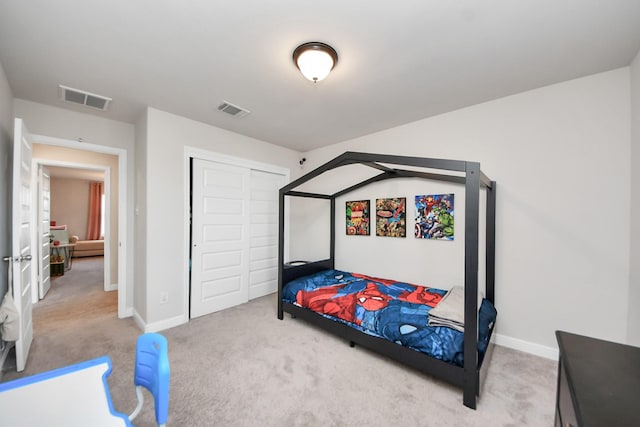 carpeted bedroom with visible vents, baseboards, and a closet