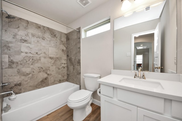 bathroom featuring visible vents, vanity, wood finished floors, bathing tub / shower combination, and toilet