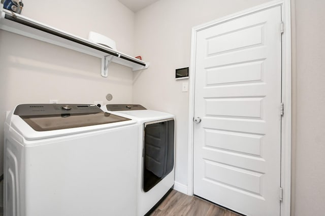 clothes washing area with separate washer and dryer, laundry area, and light wood-type flooring