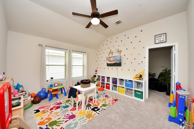 recreation room featuring carpet flooring, ceiling fan, visible vents, and lofted ceiling
