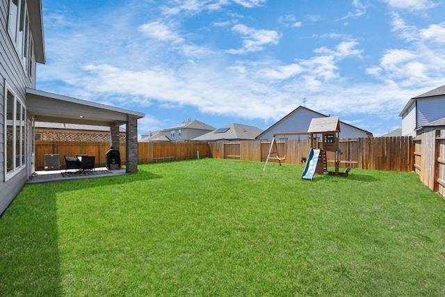 view of yard with a patio, a fenced backyard, and a playground
