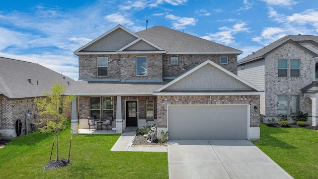craftsman-style home with a porch, an attached garage, a front yard, and concrete driveway