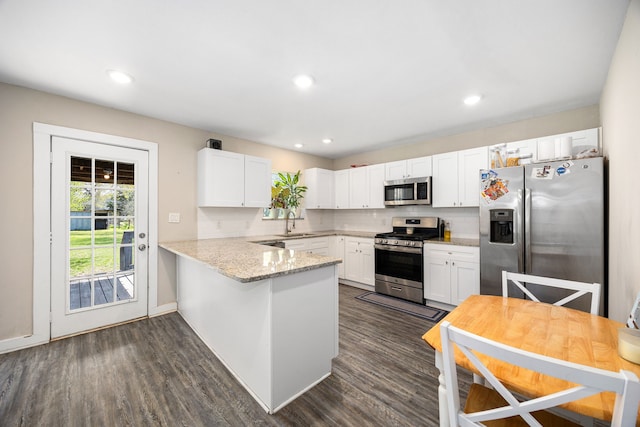415 N Meyer St, Sealy, TX 77474 - kitchen featuring a sink, white cabinetry, a peninsula, and stainless steel appliances