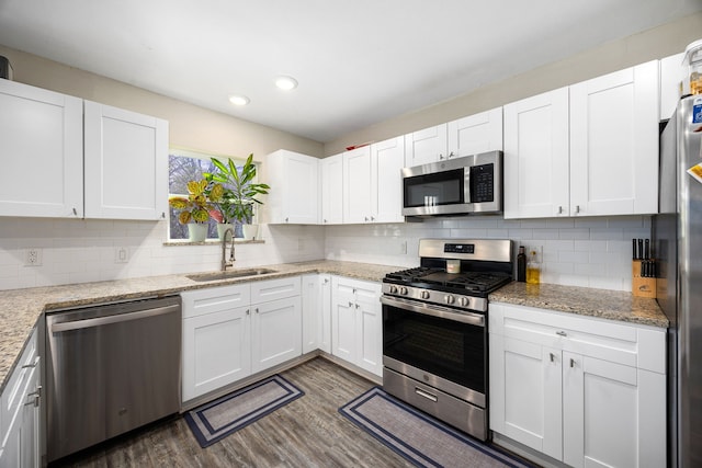 415 N Meyer St, Sealy, TX 77474 - kitchen featuring white cabinets, a sink, dark wood finished floors, stainless steel appliances, and backsplash