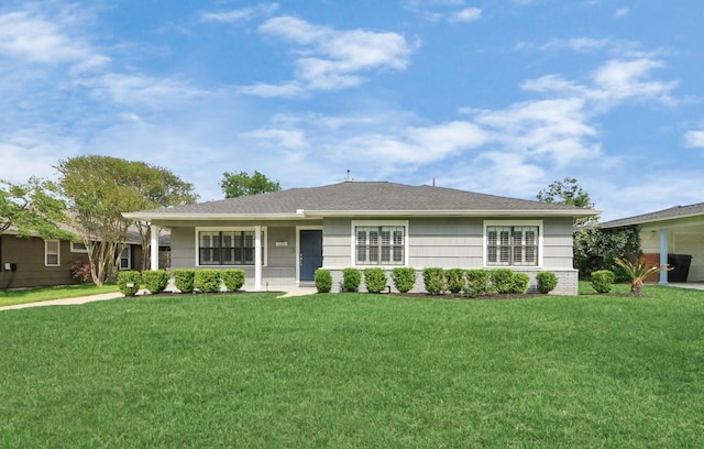 ranch-style home featuring a front lawn and roof with shingles