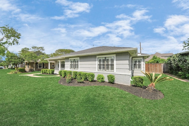 back of property with a lawn and fence