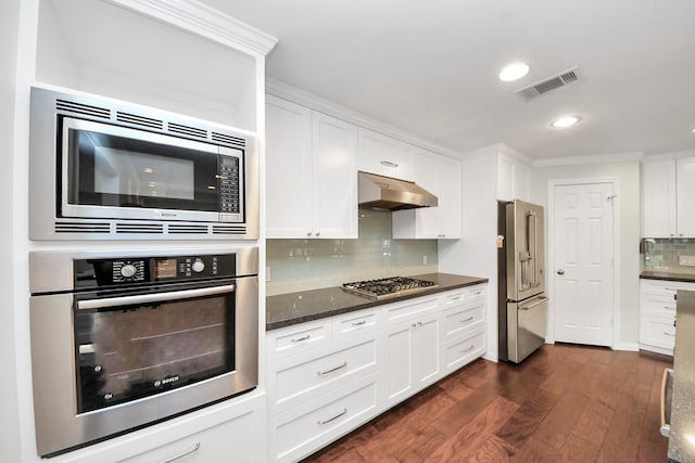 kitchen featuring tasteful backsplash, dark wood finished floors, under cabinet range hood, stainless steel appliances, and white cabinetry