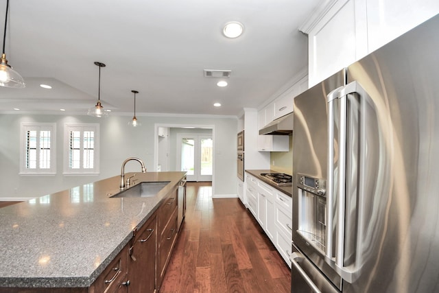 kitchen featuring visible vents, crown molding, a kitchen island with sink, a sink, and stainless steel appliances