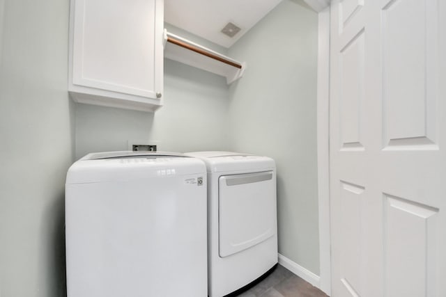 laundry area featuring cabinet space, baseboards, visible vents, and washing machine and clothes dryer