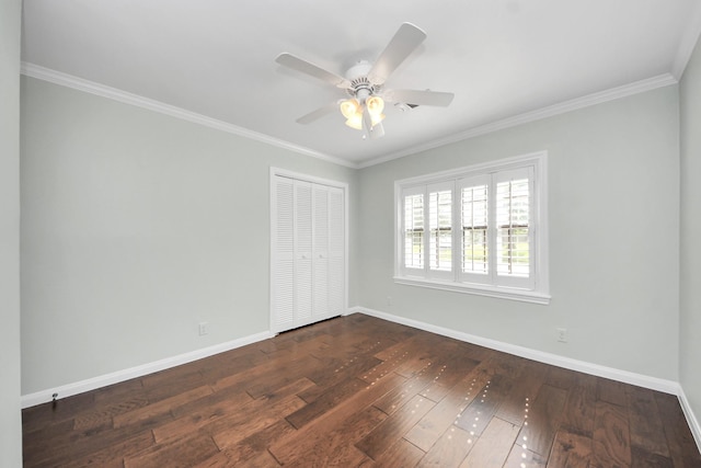 unfurnished bedroom featuring baseboards, ornamental molding, dark wood-style floors, and a closet