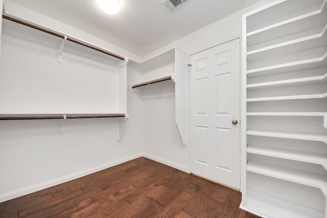 walk in closet featuring dark wood-style flooring and visible vents