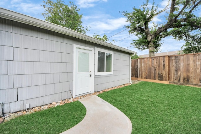 doorway to property with a yard and fence