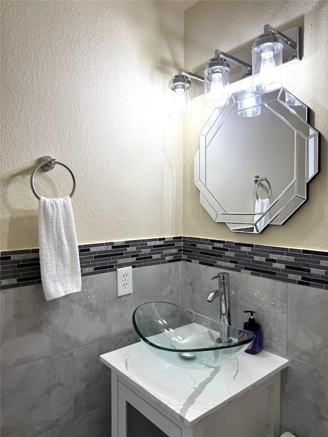 7130 Liberty Oak Ct, Houston, TX 77049 - bathroom featuring tile walls, vanity, and a textured wall