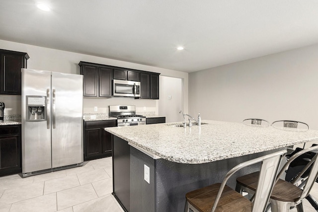 23706 Bluewood Trce, Tomball, TX 77375 - kitchen with stainless steel appliances, a sink, a breakfast bar area, light stone countertops, and recessed lighting