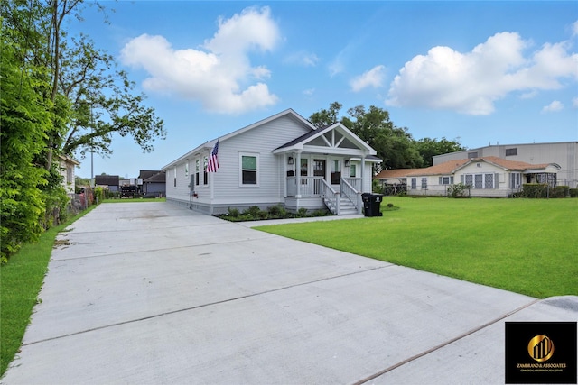 view of front of house with a porch, fence, driveway, and a front yard