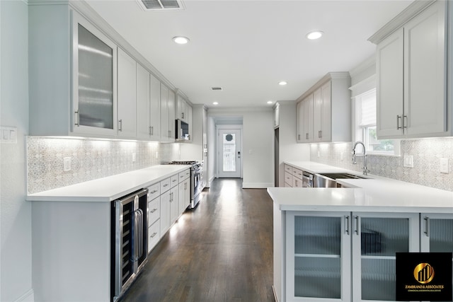 kitchen featuring beverage cooler, a sink, light countertops, and stainless steel appliances