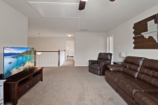 living room featuring visible vents, carpet floors, baseboards, attic access, and ceiling fan