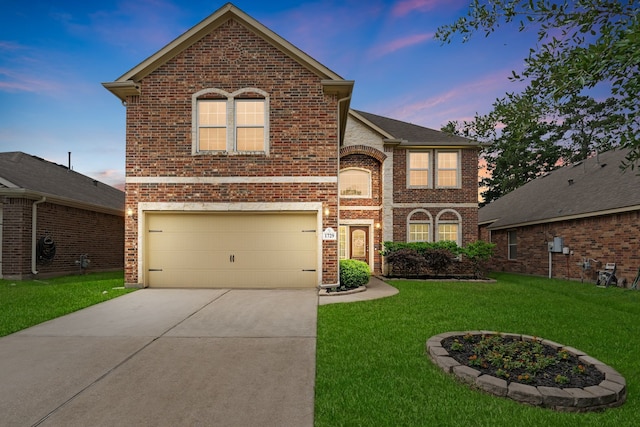 traditional-style house featuring a yard, brick siding, an attached garage, and driveway