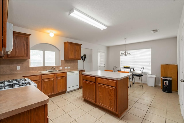 102 Pebble Walk Ln, Dickinson, TX 77539 - kitchen featuring dishwasher, a sink, decorative backsplash, a kitchen island, and light tile patterned floors