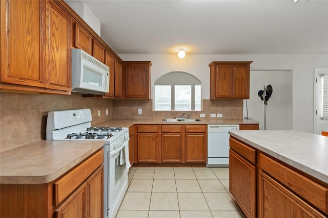 102 Pebble Walk Ln, Dickinson, TX 77539 - kitchen featuring white appliances, a sink, decorative backsplash, and brown cabinets