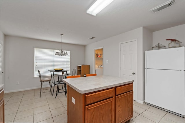 102 Pebble Walk Ln, Dickinson, TX 77539 - kitchen with freestanding refrigerator, light tile patterned flooring, a chandelier, light countertops, and a kitchen island