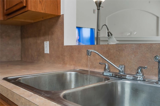102 Pebble Walk Ln, Dickinson, TX 77539 - kitchen view of a sink, decorative backsplash, and brown cabinets