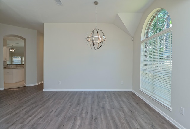 unfurnished dining area with arched walkways, wood finished floors, and a wealth of natural light