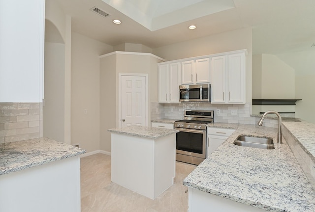 kitchen featuring backsplash, light stone countertops, a sink, stainless steel appliances, and recessed lighting