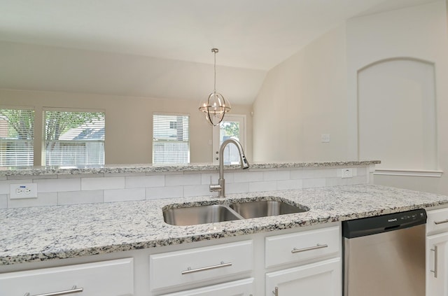 kitchen featuring stainless steel dishwasher, lofted ceiling, white cabinetry, a chandelier, and a sink