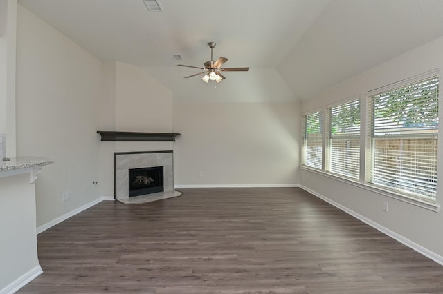 unfurnished living room with ceiling fan, vaulted ceiling, dark wood-type flooring, and a premium fireplace