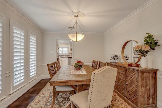 dining room featuring baseboards, visible vents, ornamental molding, and dark wood finished floors