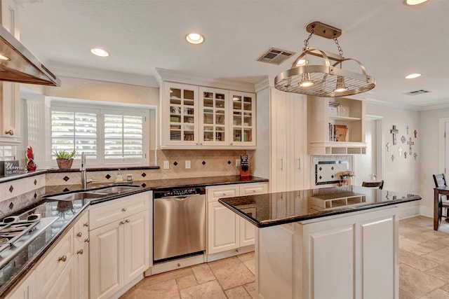 kitchen with stone tile floors, a sink, appliances with stainless steel finishes, and ornamental molding