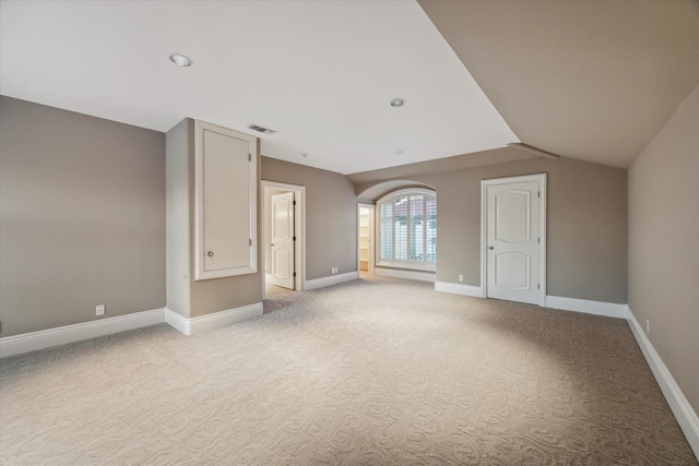 empty room with baseboards, visible vents, and light colored carpet