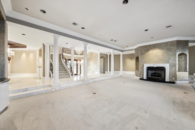 unfurnished living room featuring crown molding, carpet floors, a premium fireplace, decorative columns, and visible vents