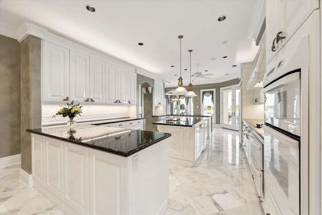 kitchen featuring french doors, marble finish floor, decorative backsplash, a kitchen island, and ornamental molding