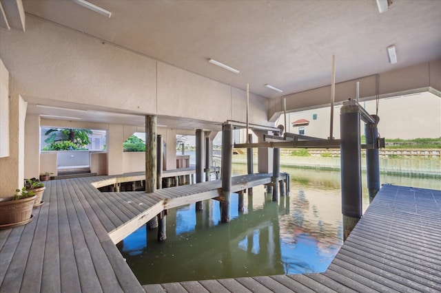 dock area with boat lift and a water view