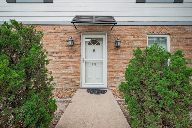 entrance to property with visible vents and brick siding