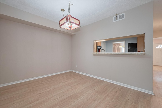 772 Thicket Ln, Houston, TX 77079 - empty room featuring a textured ceiling, baseboards, visible vents, and light wood-style floors