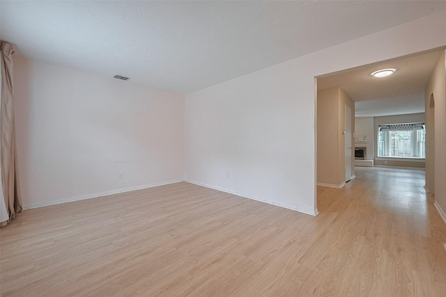 unfurnished room featuring light wood-style floors, baseboards, and visible vents