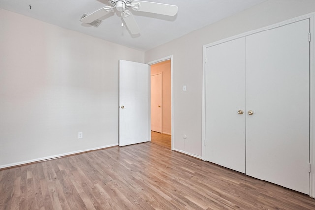 unfurnished bedroom featuring baseboards, ceiling fan, a closet, and wood finished floors
